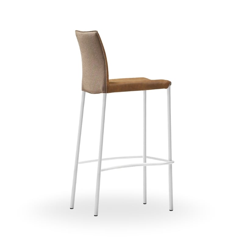 A tall bar stool with a beige upholstered seat and backrest, supported by white metal legs.