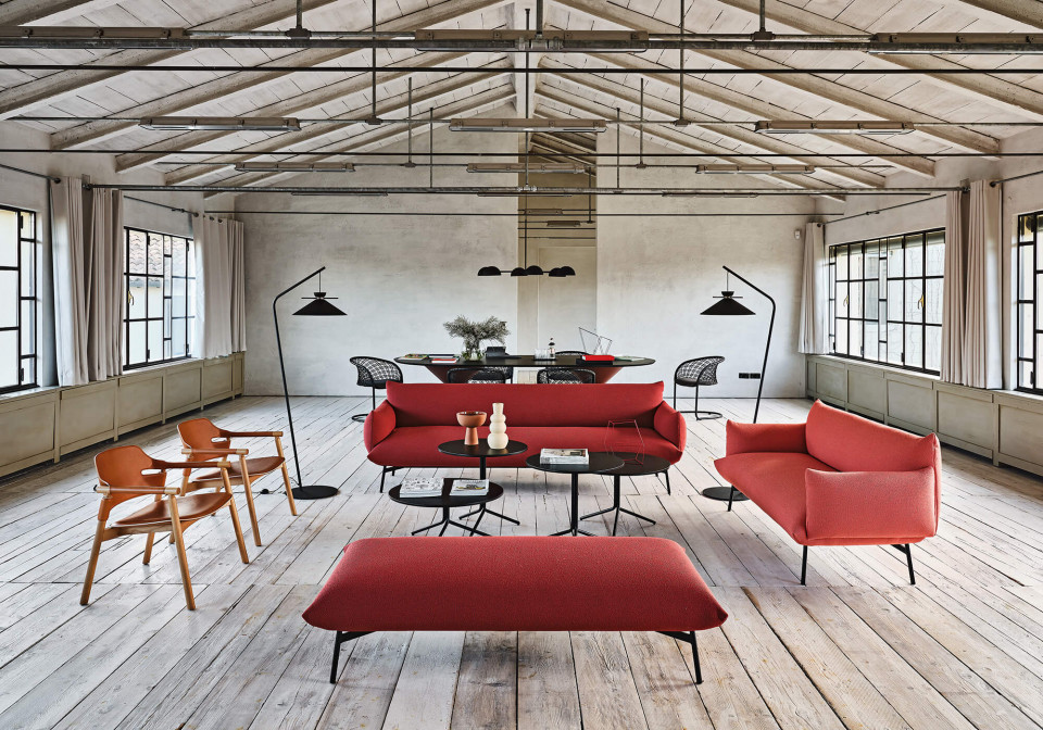 Modern lounge for a workspace. Area sofas and ottonam in red fabric