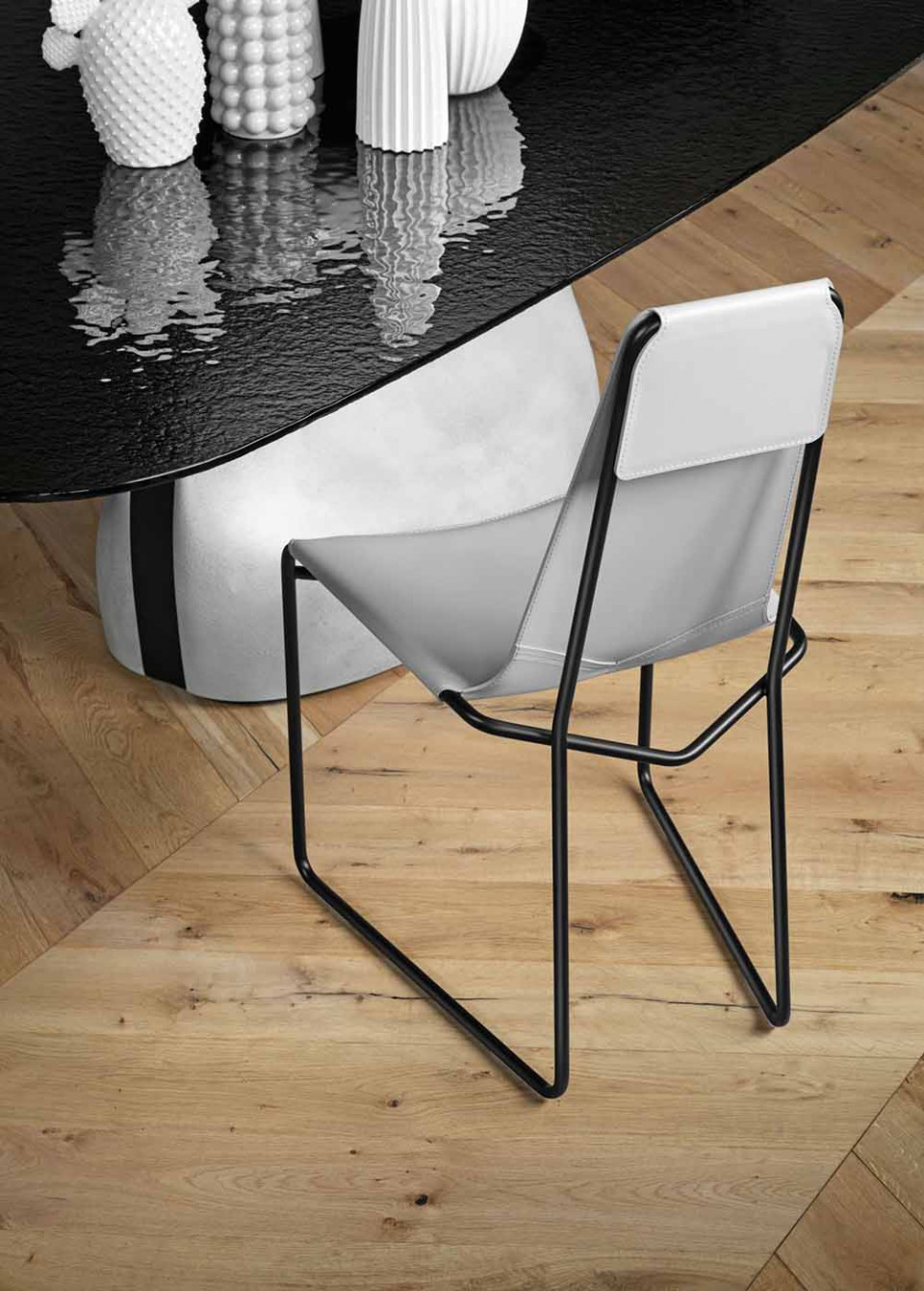 Chair with sled base in black metal, seat in light grey hide
