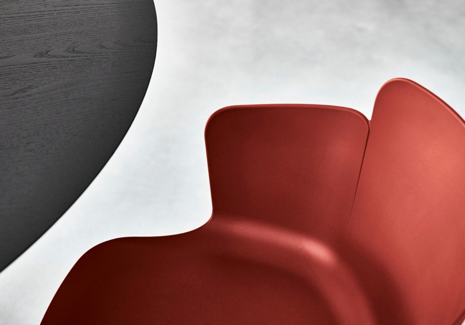 Particolare poltrona Calla con sedile in polipropilene rosso bulgaro e struttura in legno