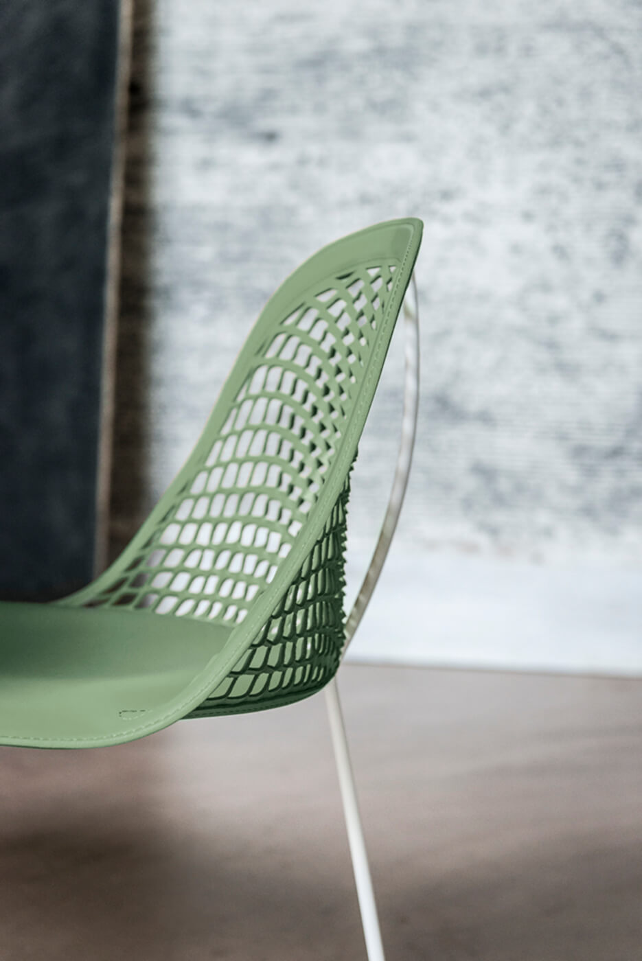 Détail de la chaise Guapa avec assise en cuir vert et structure en métal