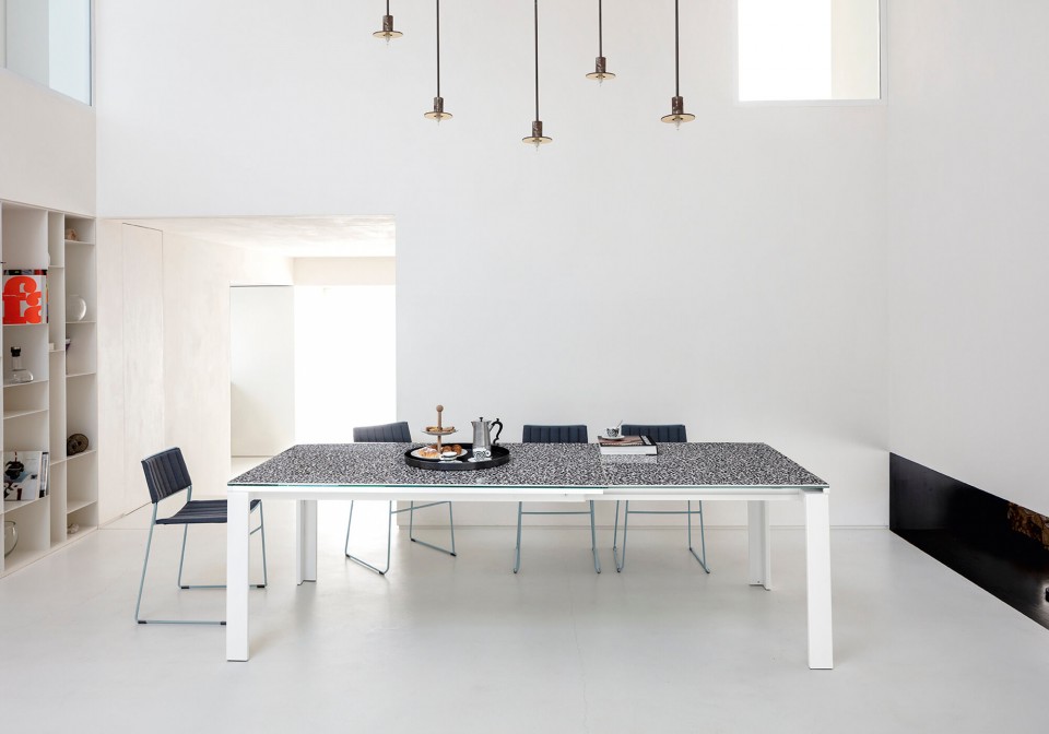 Tavolo allungabile Marcopolo con base a quattro gambe in metallo bianco, piano e allunghe in cristalceramica effetto marmo veneziano