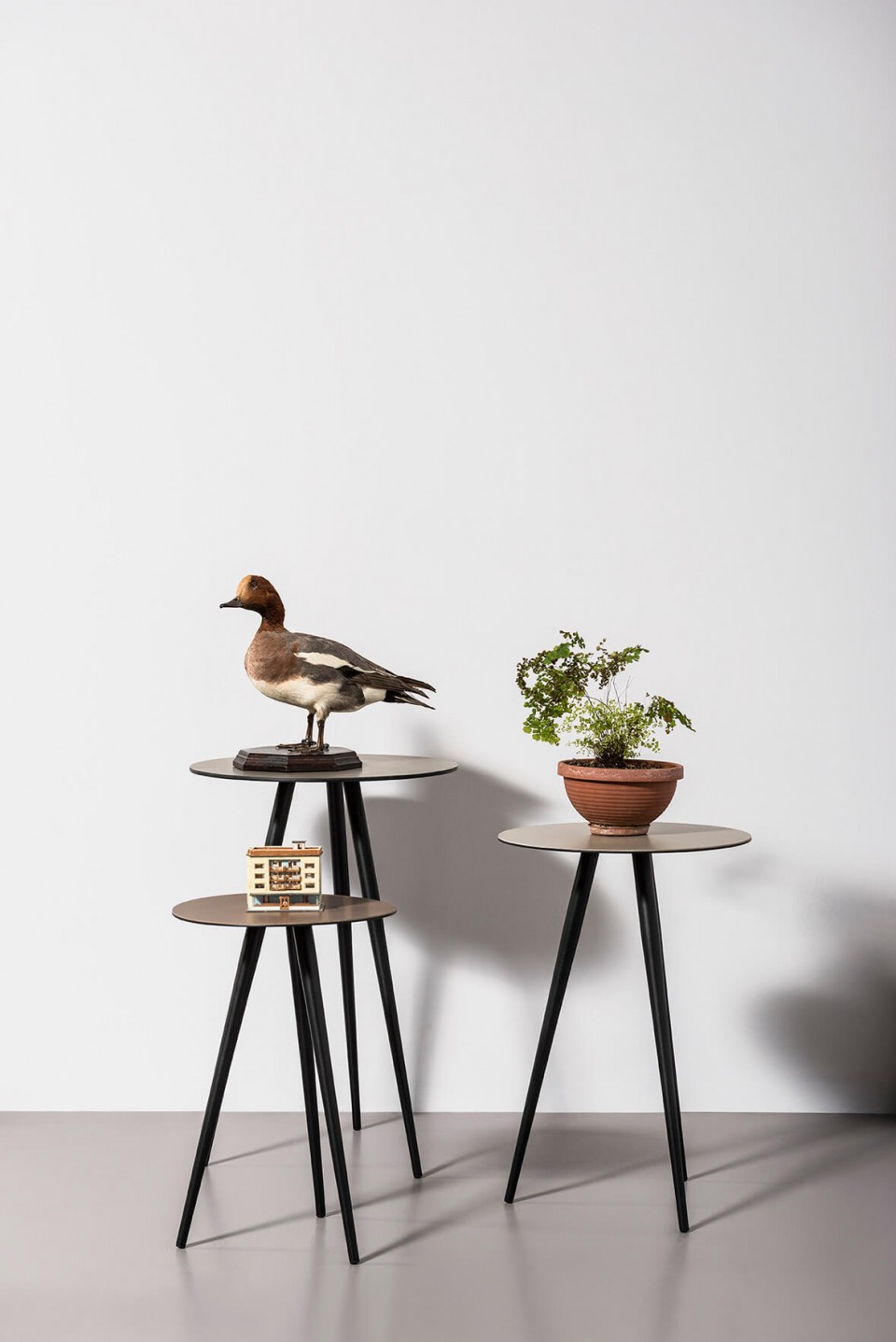 Ensemble de trois tables basses Trip de différentes hauteurs. Base avec trois pieds en acier graphite et dessus en cuir couleur fango