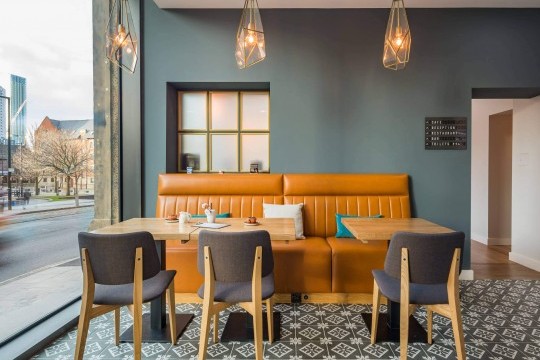 The Joe design chairs with wooden legs in natural oak finish and upholstered in fabric furnish the M Cafè of the Hotel Indigo in Manchester