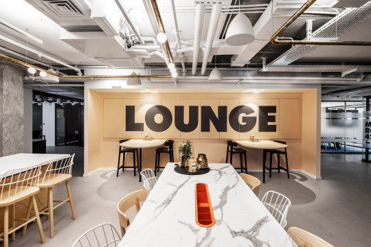Wooden Maya stools in the lounge area of Rooms co-working