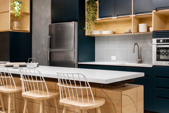 Strtike wooden stools with white painted backrest in the lounge area of Rooms co-working